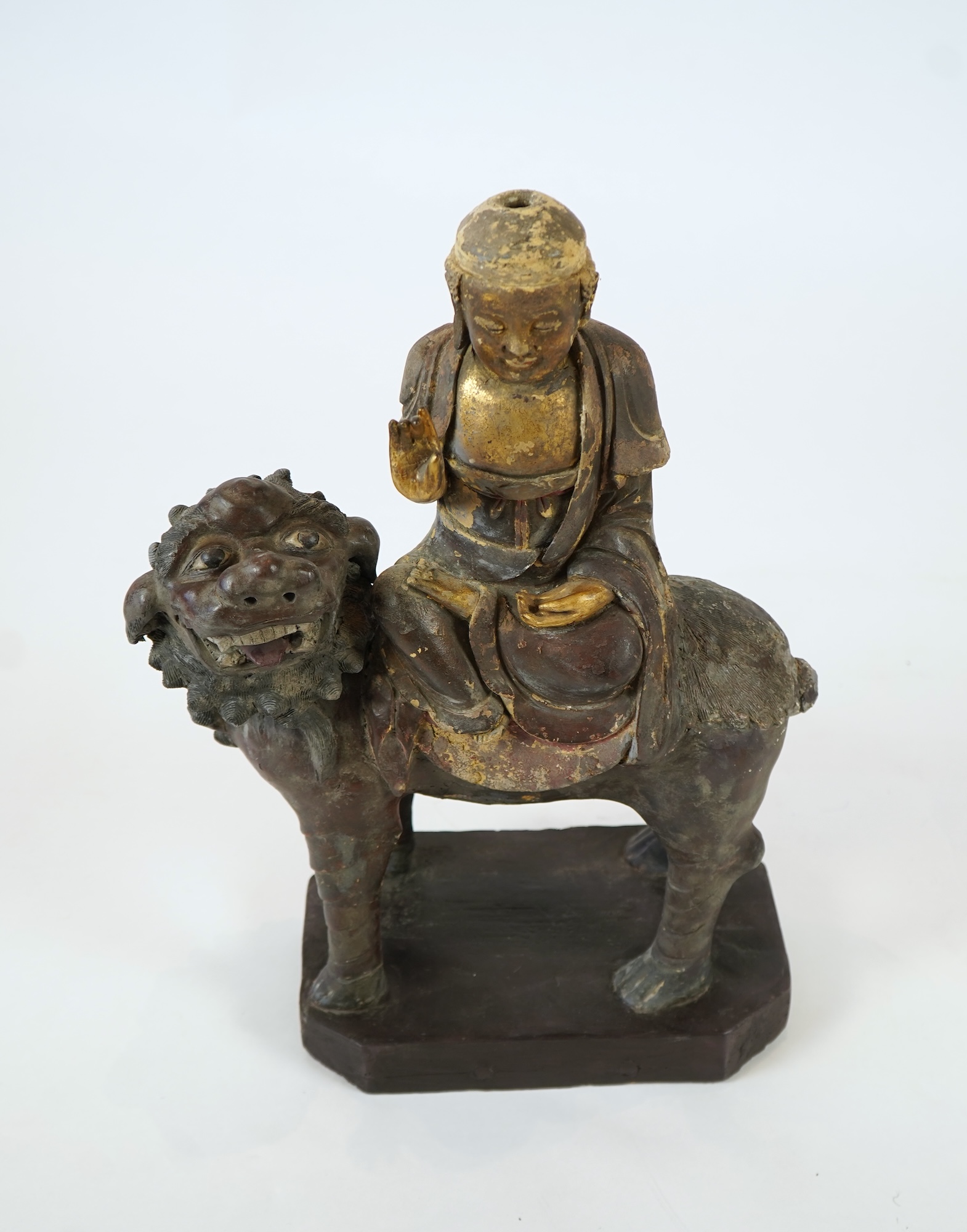 A Chinese gilt and polychrome lacquered stucco work and wood figure of Manjushri on a lion, Yuan-Ming dynasty
